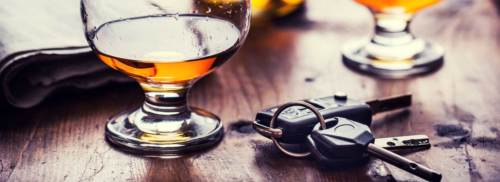 Car keys next to glasses with alcohol in them