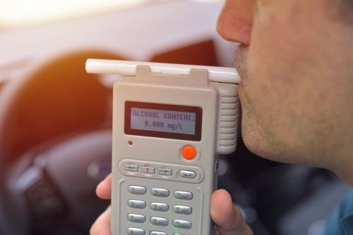A man using a DUI breath test device